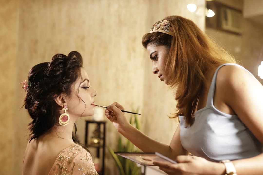 Madhu Gupta applying makeup to a bride at MG Makeovers