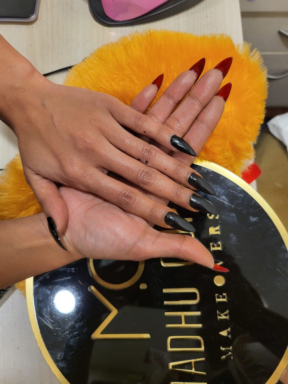 Dark red stiletto nail extensions displayed on the MG Makeovers plate