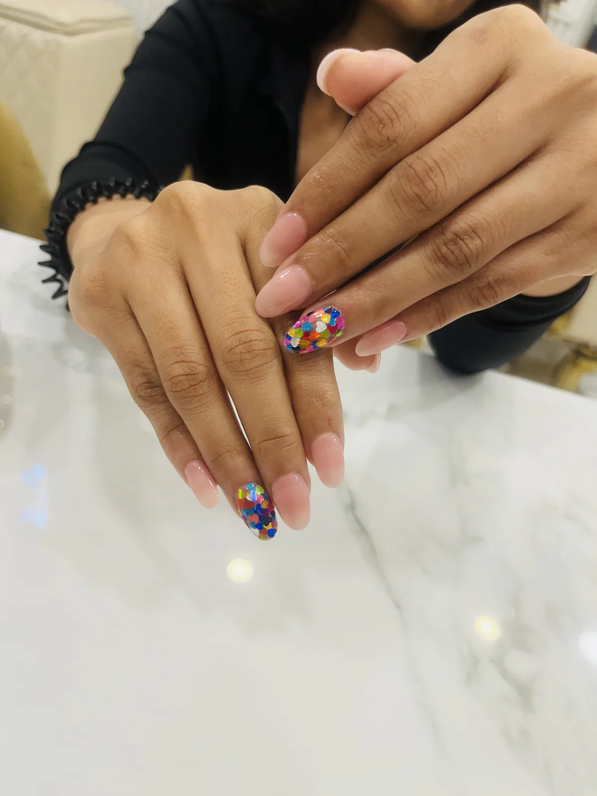 Pink nail extensions with colourful confetti accent nail art