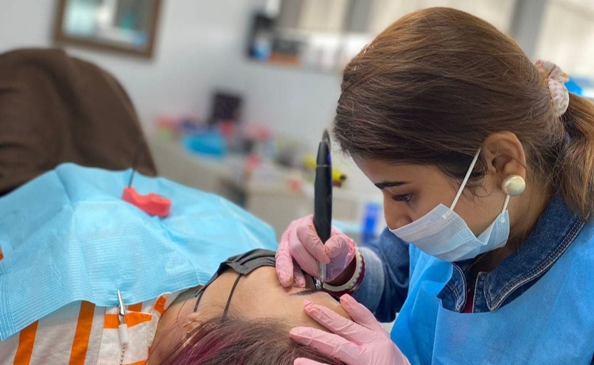 Madhu Gupta performing a permanent makeup treatment at MG Makeovers